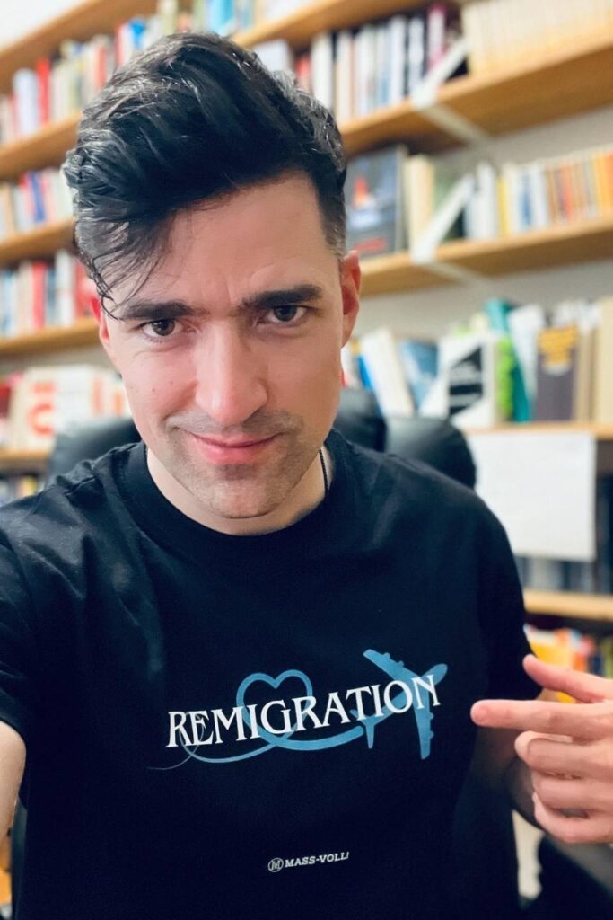 Martin Sellner posiert mit dem Remigration T-Shirt von Massvoll